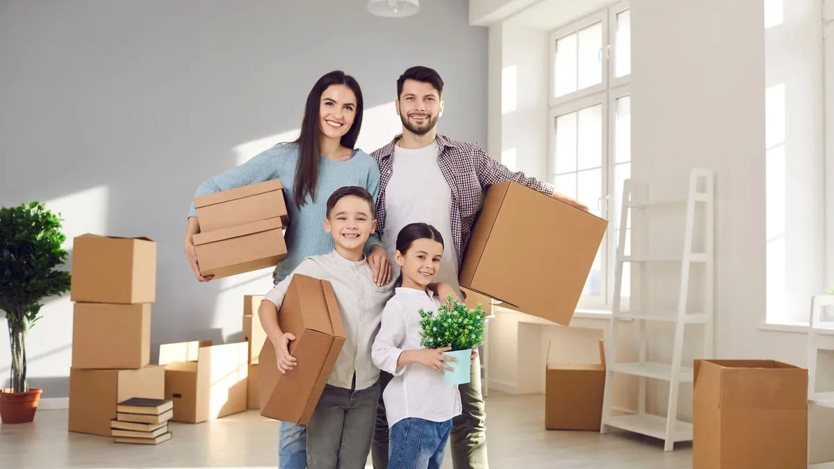 Familia con cajas de mudanza en su casa nueva