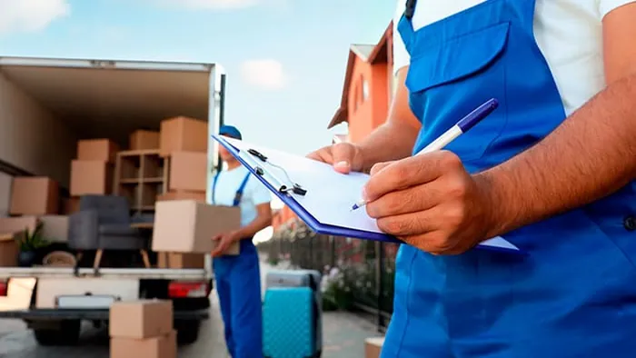 Operario revisando el inventario de cajas antes de cargar un contenedor de mudanza internacional